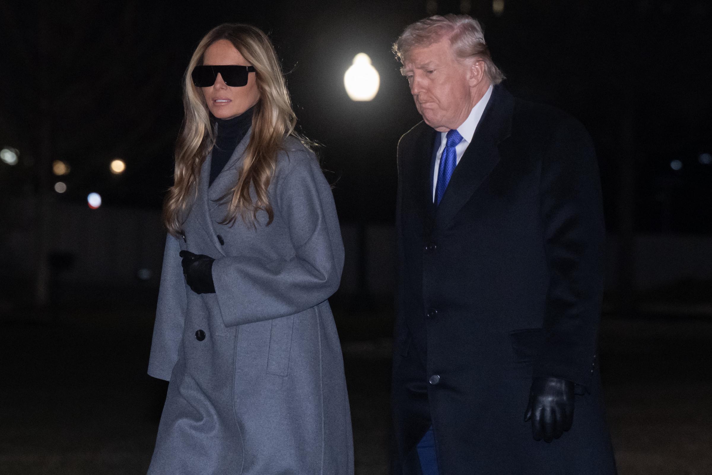 Donald Trump and Melania Trump walk across the South Lawn of the White House after arriving on Marine One on February 16, 2026, in Washington, DC | Source: Getty Images