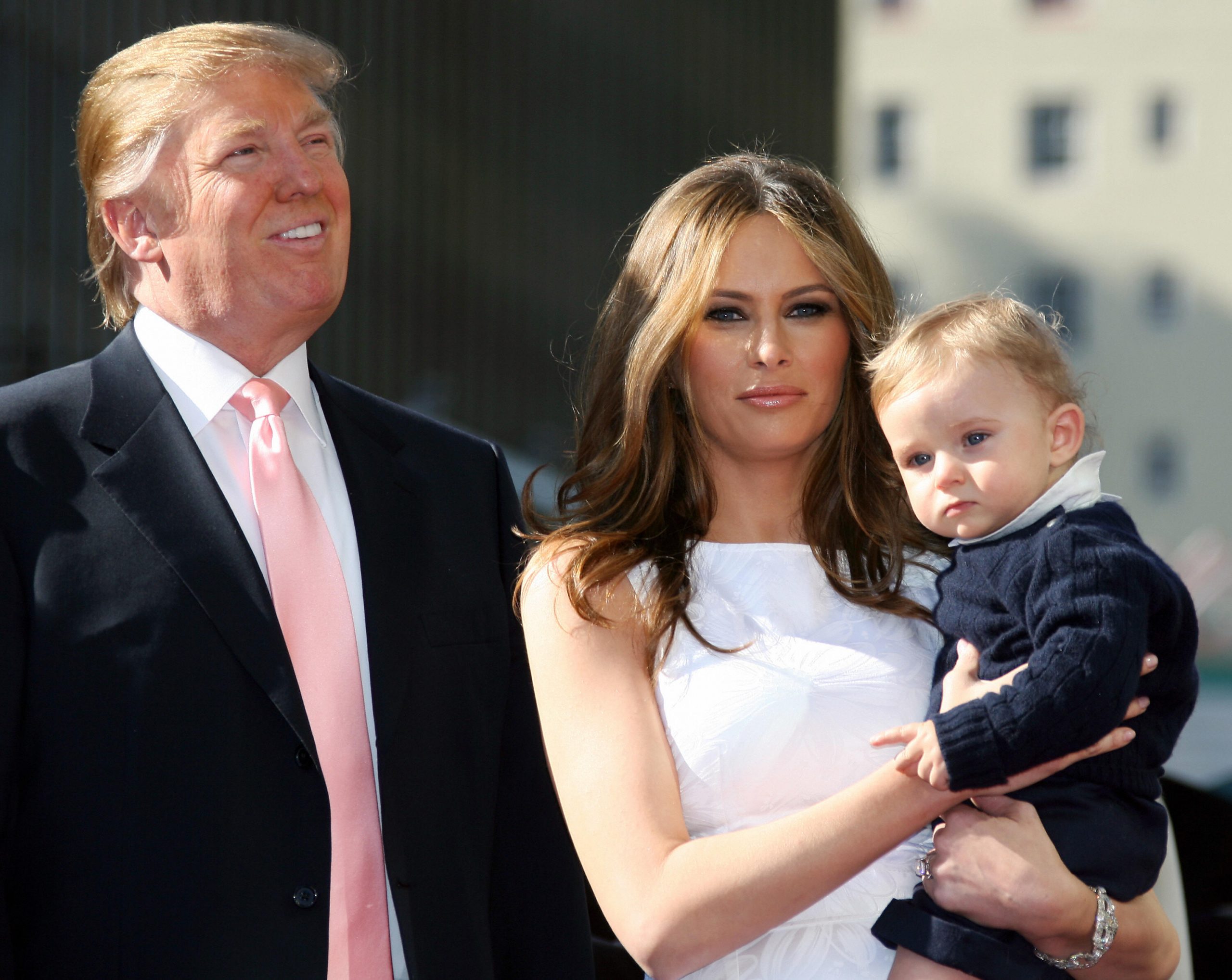 On Hollywood Boulevard, Melania Trump holds 10-month-old Barron as the family listens to speeches. Standing beside them, Donald Trump looks on after receiving his 2,327th star. The trio appears together during his Hollywood Walk of Fame ceremony in California.
