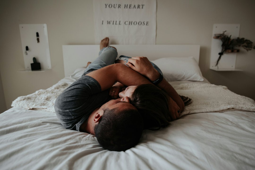 A couple cuddling in bed | Source: Unsplash