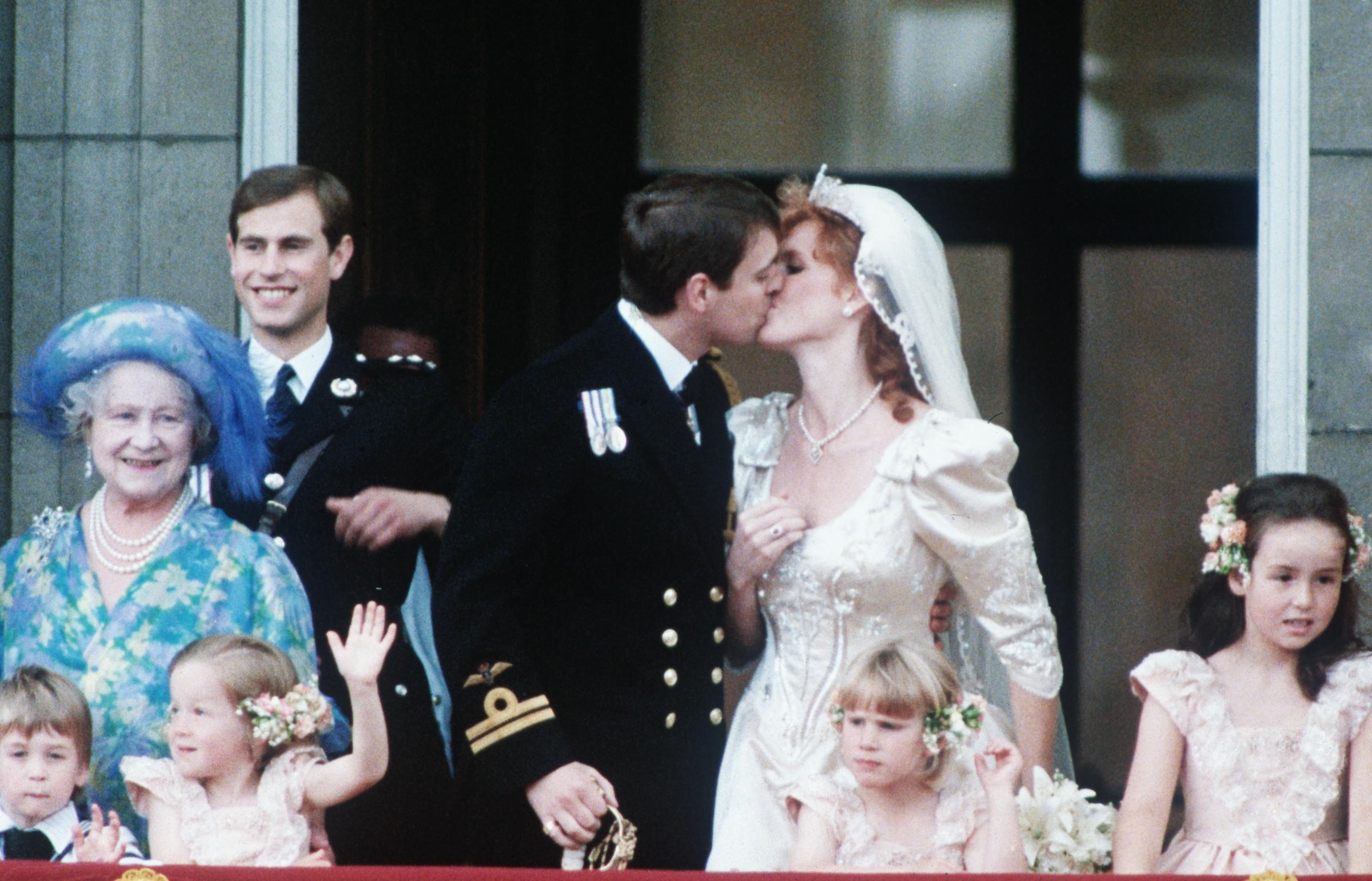 Andrew Mountbatten-Windsor and Sarah Ferguson sharing a kiss on a balcony following their wedding ceremony at Buckingham Palace in 1986. | Source: Getty Images