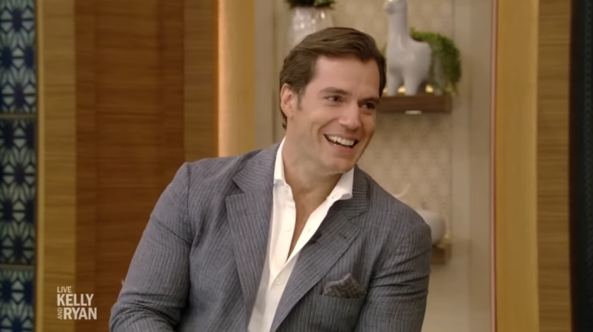 Henry Cavill smiled as the conversation turned humorous, prompting visible amusement from Kelly Ripa and Ryan Seacrest. | Source: YouTube/LiveKellyandMark