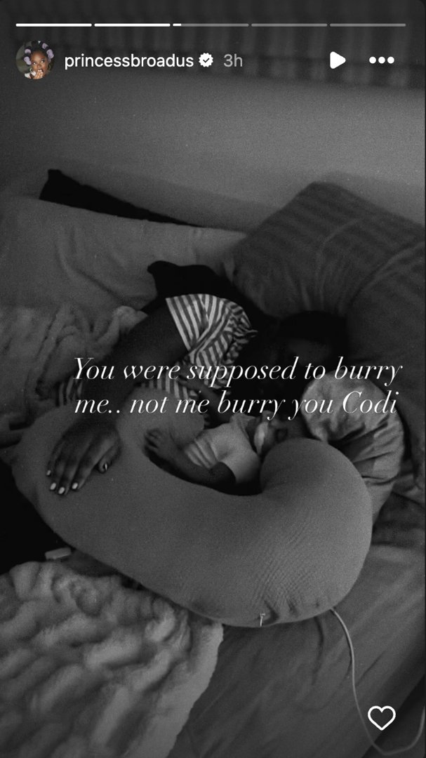 Cori Broadus lies beside her newborn daughter in a black-and-white image | Source: Instagram/princessbroadus