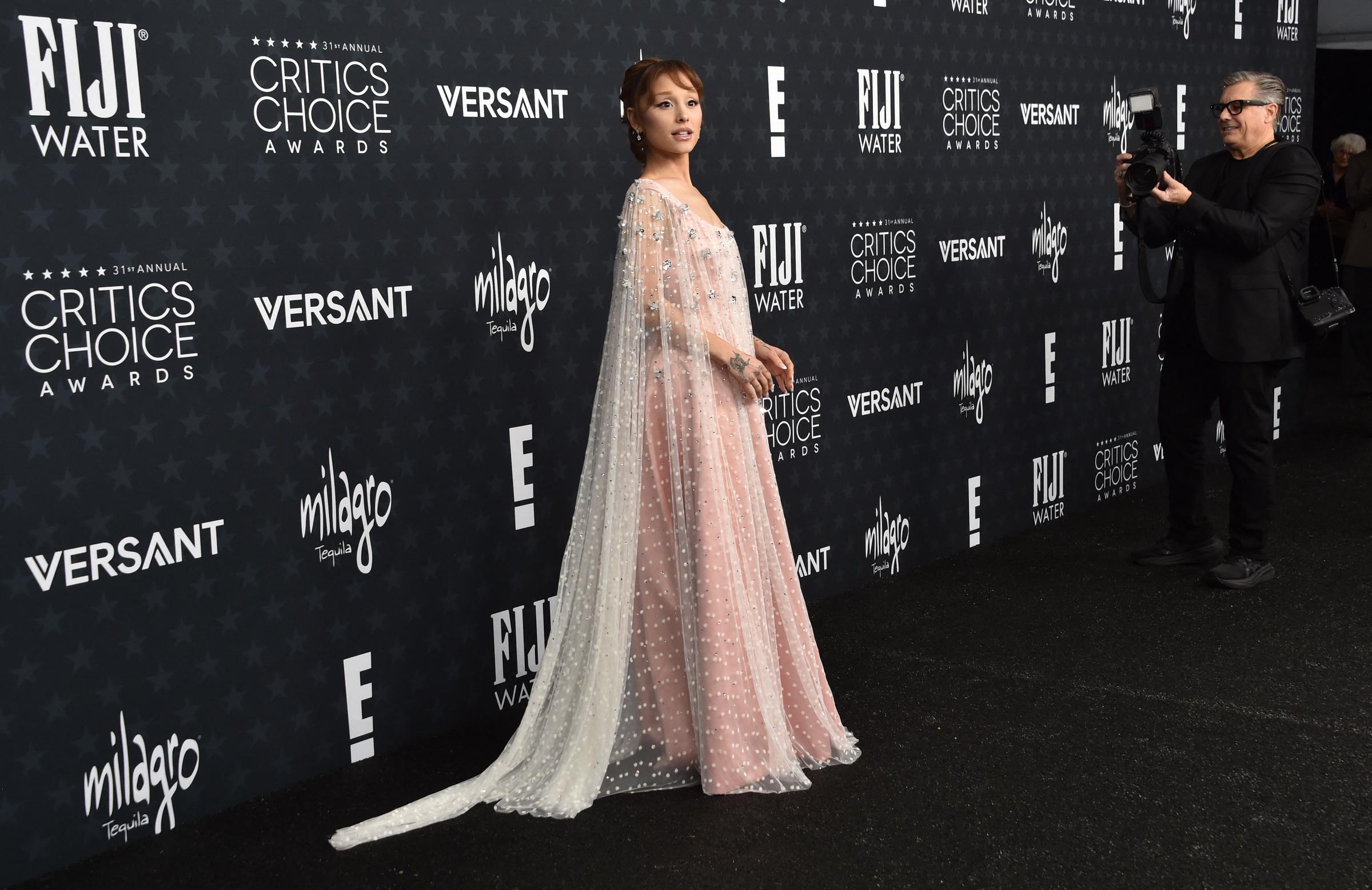 Ariana Grande shows off the full flow of her gown and cape detailing in a wide shot from the arrivals | Source: Getty Images