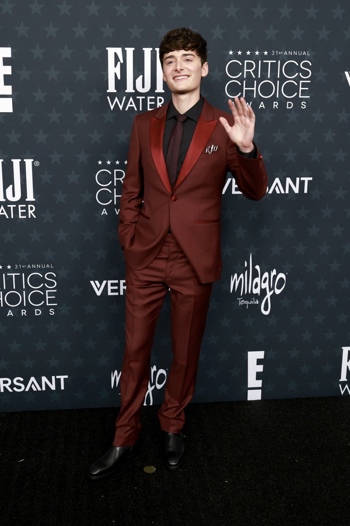 Noah Schnapp steps out in a burgundy suit with black accents, bringing youthful energy and polish to the Critics Choice red carpet | Source: Getty Images