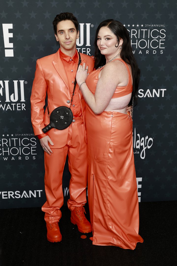 Paul W. Downs and Megan Stalter coordinate in bright orange looks, bringing playful energy and bold color to the red carpet | Source: Getty Images