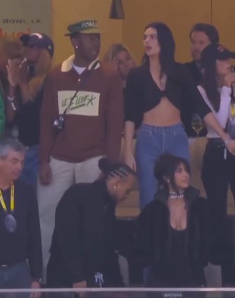 Kendall Jenner looks on as she stands beside Tyler, the Creator and behind Lewis Hamilton and Kim Kardashian. | Source: Instagram/nfl