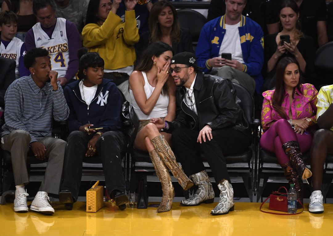 Kendall Jenner whispers something to Bad Bunny as Renell Medrano and Yung Taco look on during the basketball game. | Source: Getty Images