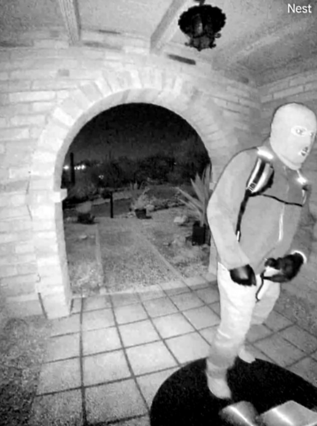A masked individual standing beneath the brick entryway at Nancy Guthrie's Arizona home | Source: x/PimaSheriff