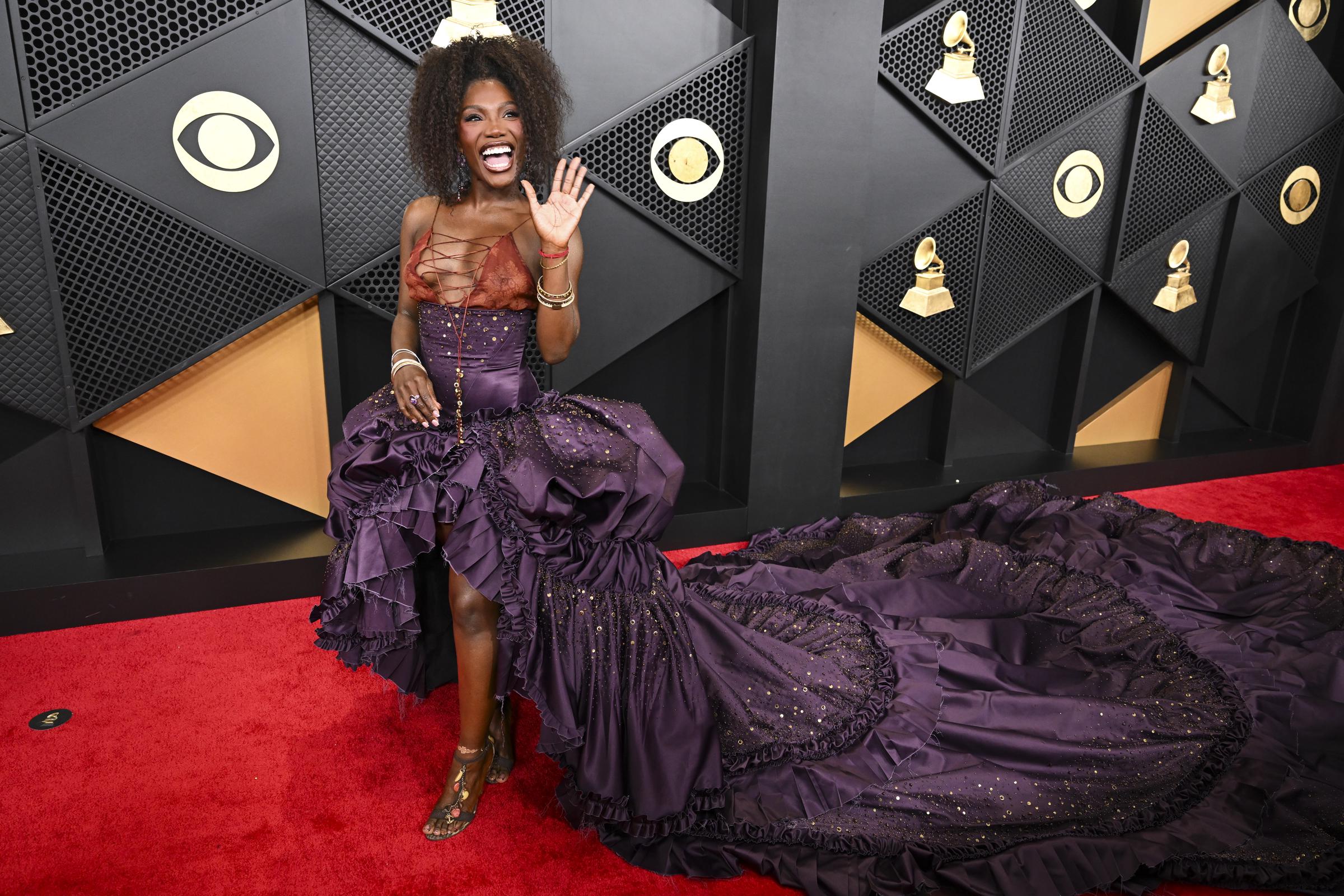 Doechii smiles and waves to photographers as she steps forward | Source: Getty Images