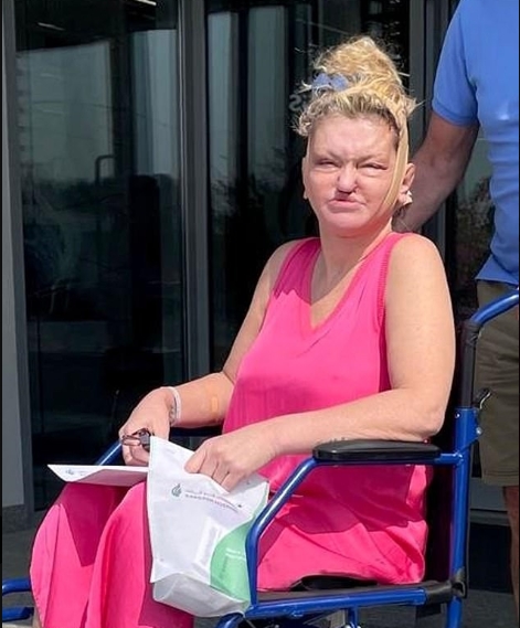 Danniella Westbrook leaves Gargash Hospital in a wheelchair following a full face, neck and brow lift, with a compression garment secured around her head. | Source: X/DailyMailUK