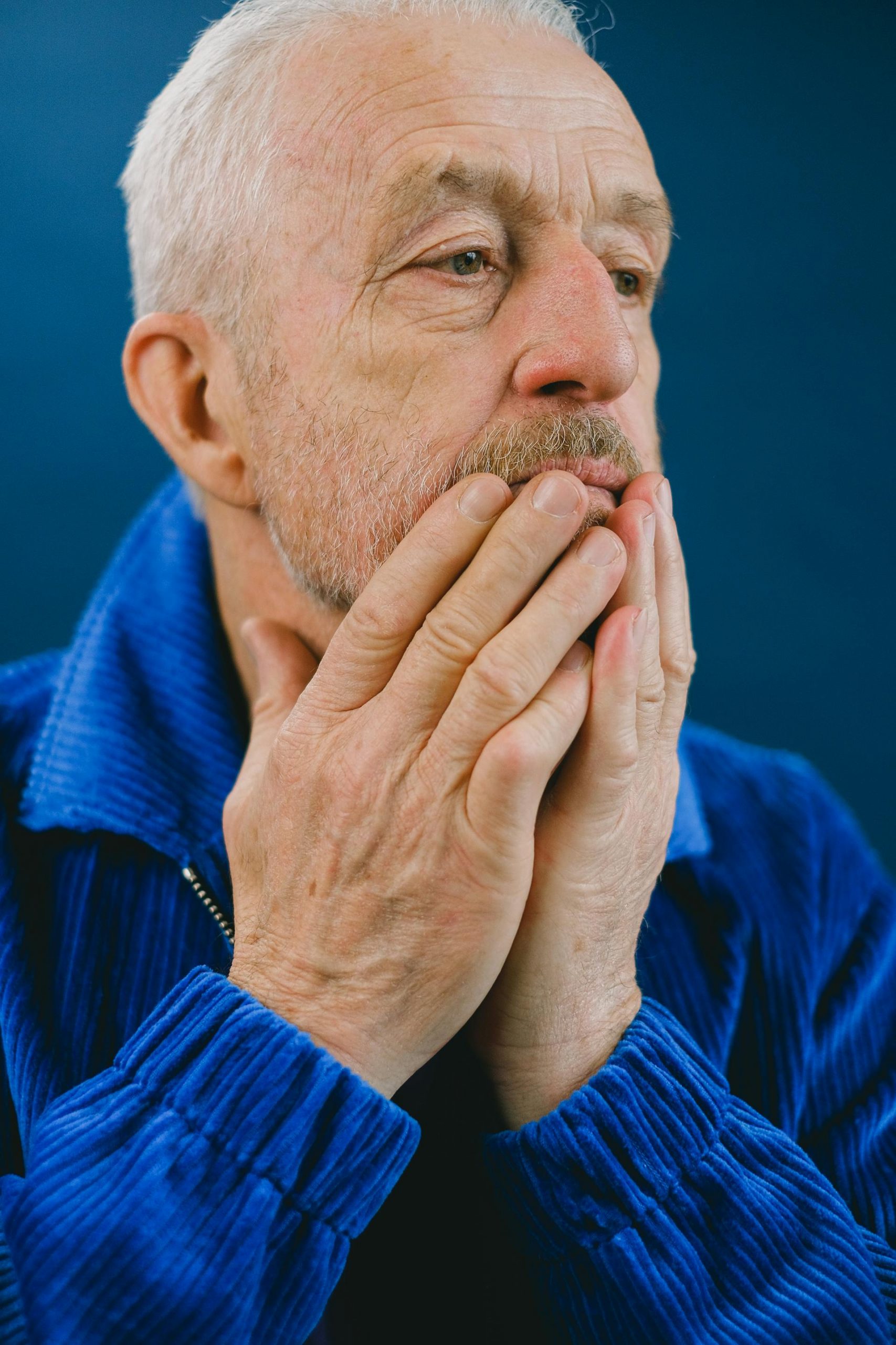 An older man standing with his hands on his face | Source: Pexels