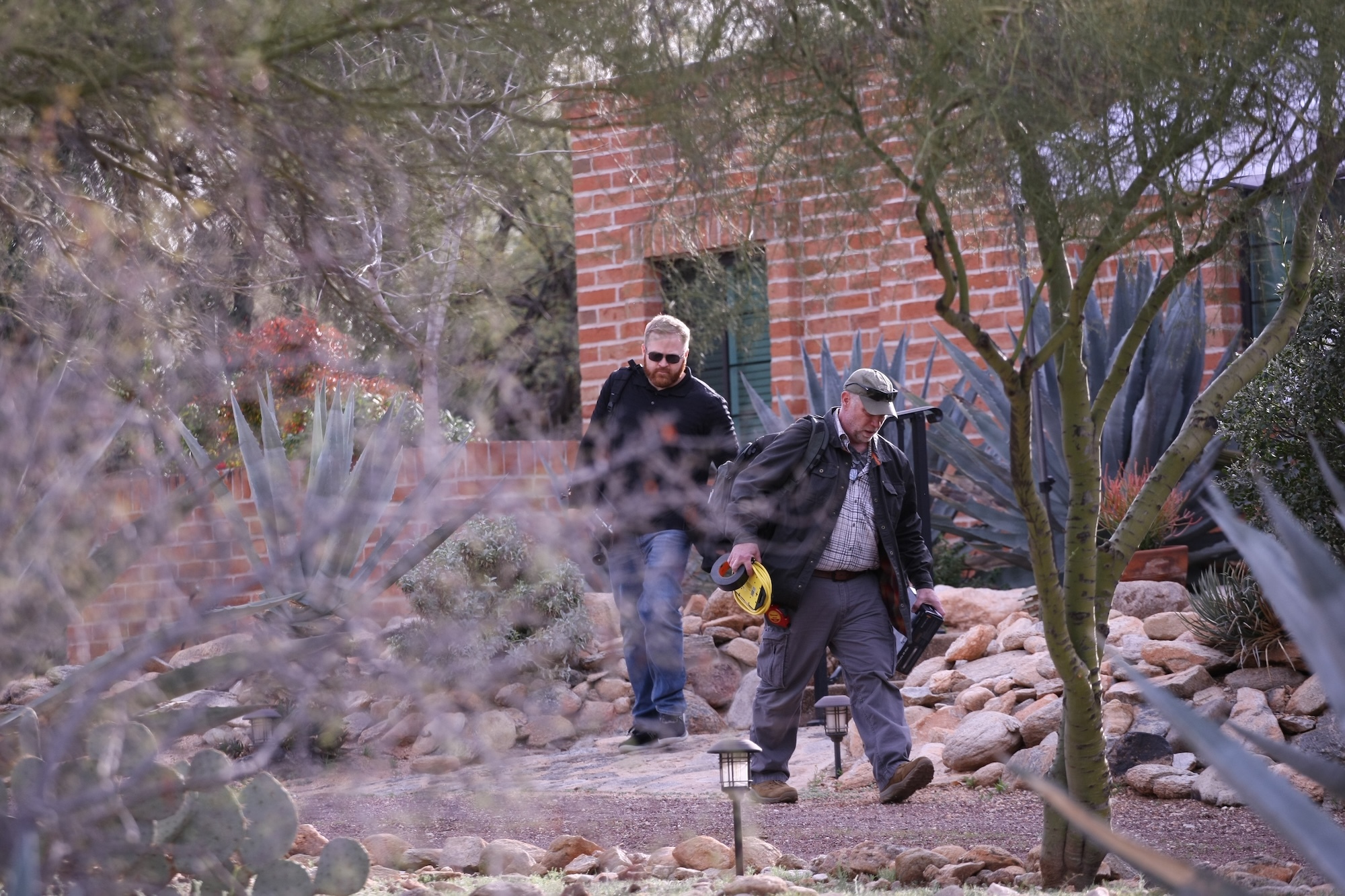 Investigators walk the grounds outside Nancy Guthrie's home during the ongoing investigation on February 12, 2026 | Source: Getty Images