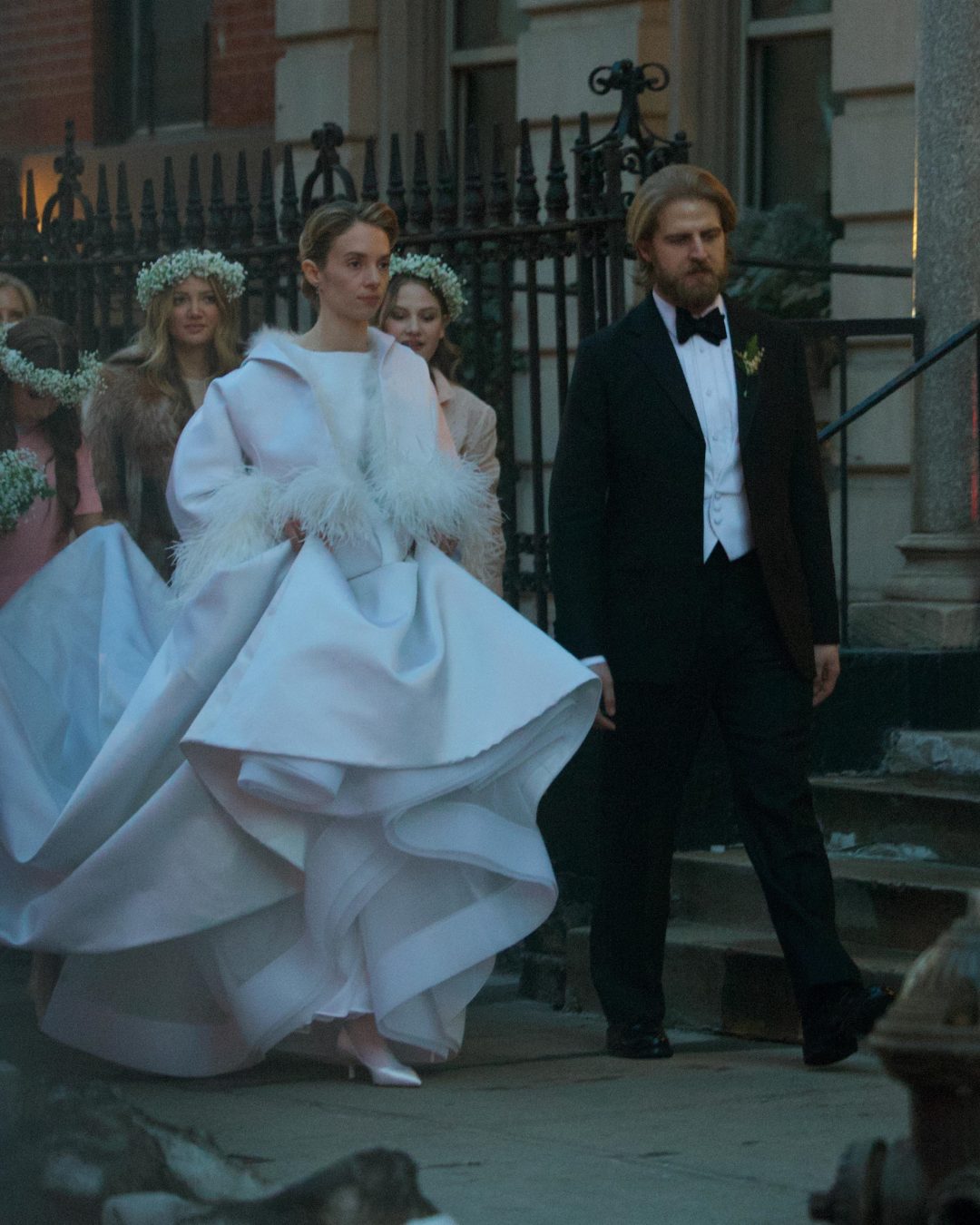 Maya descended the church steps like she'd stepped out of a black-and-white film — timeless, serene, unforgettable. Her sculptural white gown billowed in the breeze, echoing vintage glamour with bold volume and feather-trimmed softness. Against the Manhattan skyline, with her hair swept back and a look of calm radiance, she looked every bit the leading lady alongside her husband. | Source: Instagram/pagesix