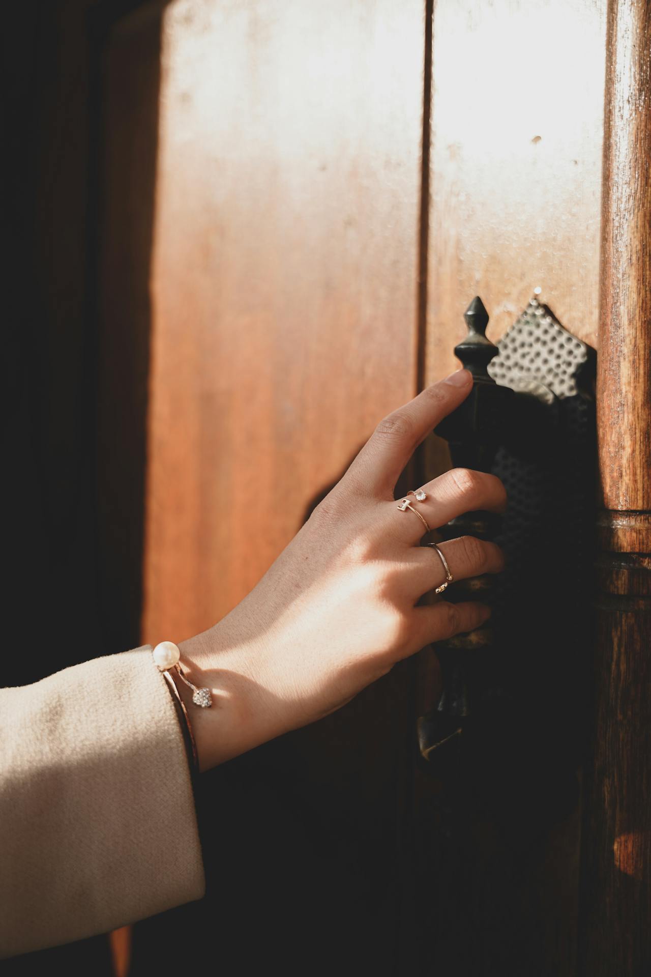 A woman holding a door handle | Source: Pexels