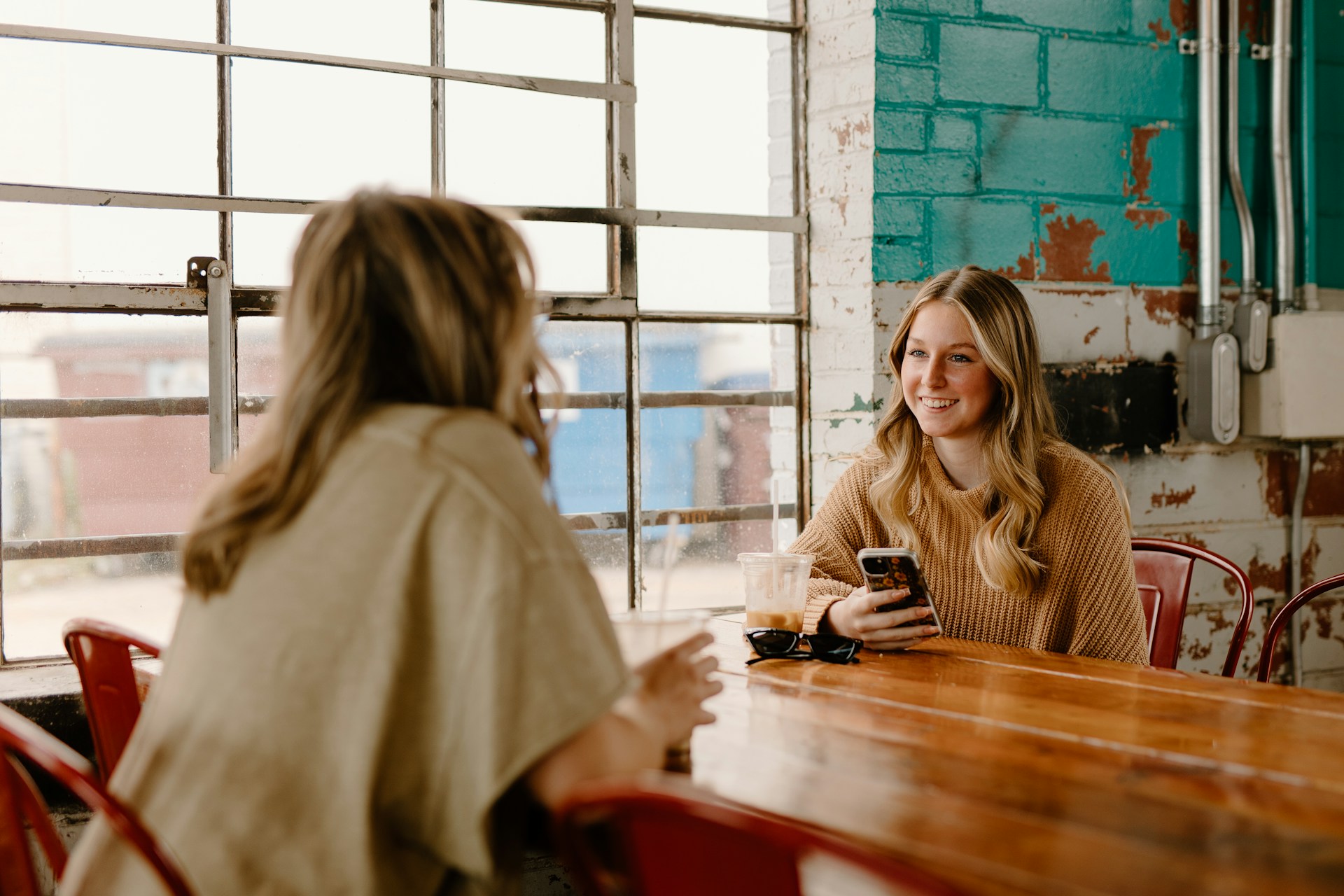 Two women chatting in a coffee shop | Source: Unsplash