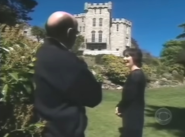 Standing in the sunlit garden with the castle towering behind her, Enya appears relaxed and at ease, speaking with an interviewer as the stone exterior dominates the backdrop. The setting underscores how closely her identity has become intertwined with the historic home she quietly renovated. | Source: YouTube/AndreW