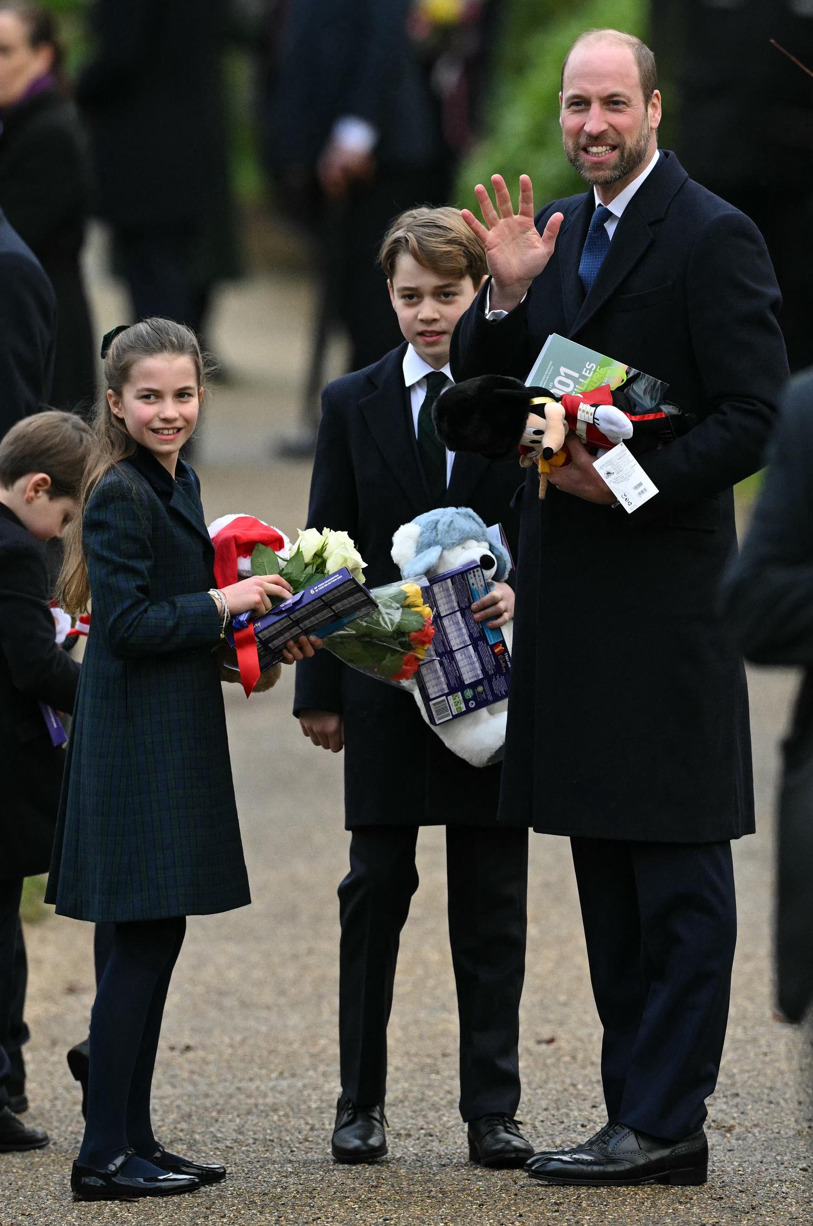 Prince William, Prince of Wales and his children Prince George (C), Princess Charlotte and Prince Louis hold gifts from wellwishers after attending the Royal Family's traditional Christmas Day service at St Mary Magdalene Church on 25 December 2024 in Sandringham, Norfolk, England. | Source: Getty Images