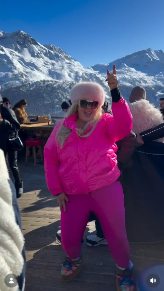 Gemma Collins posing confidently in her bright pink ski outfit, with fellow holidaymakers and alpine scenery visible behind her. | Source: Instagram/gemmacollins