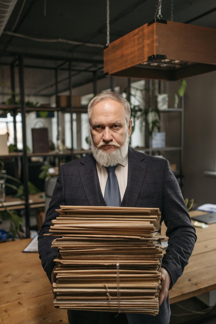 A serious man with a stack of folders | Source: Pexels