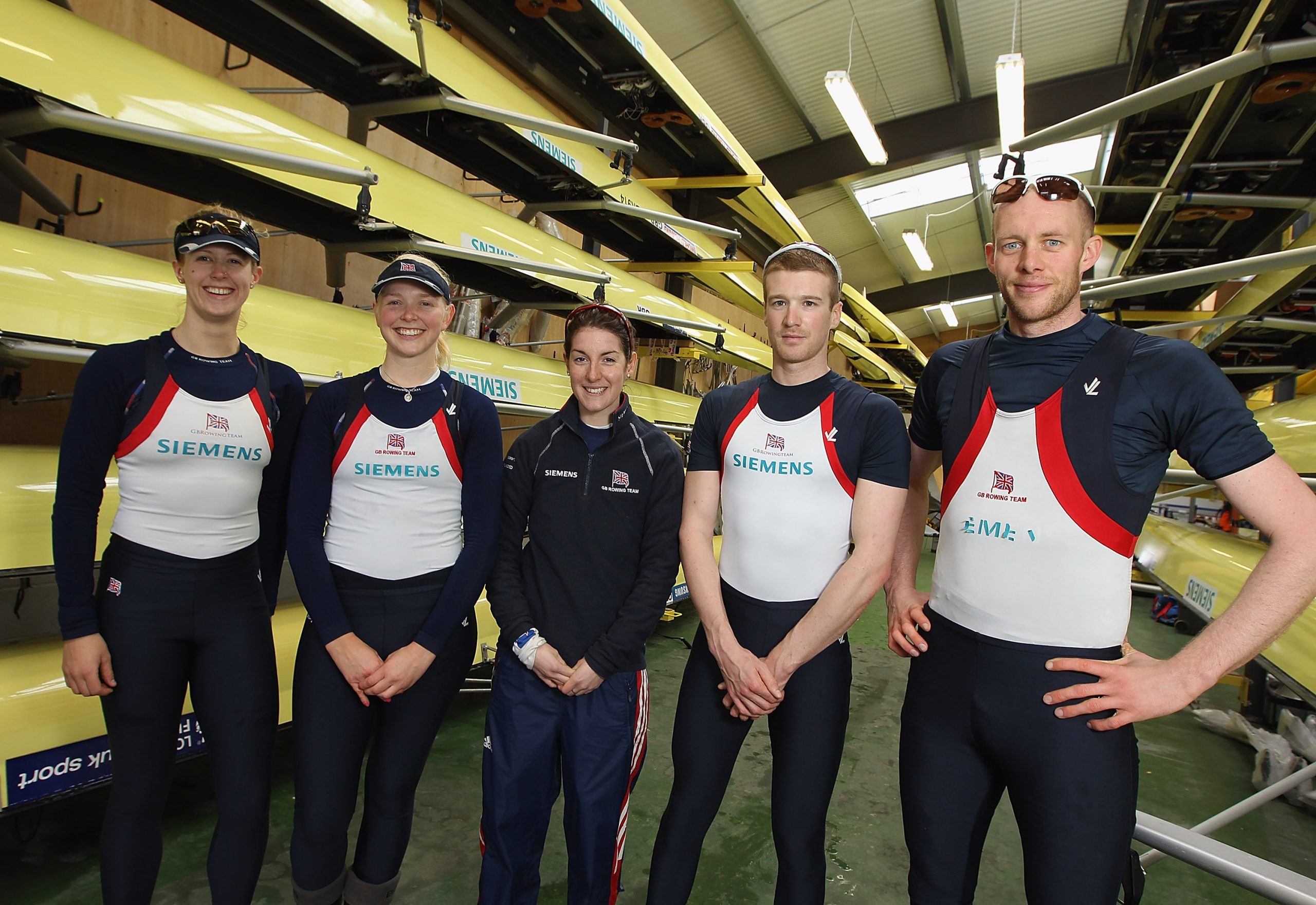Strength in Sync: At the far right of the frame, Smith stands tall beside his coxed four teammates during a gruelling adaptive rowing session on 29 February 2012 in Caversham. Dressed head to toe in GB kit, he exudes strength and precision as the team sharpen their focus for the London 2012 Games.