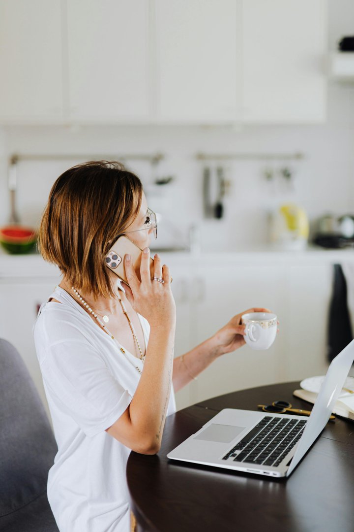 Woman talking on the phone while holding a beverage| Source: Pexels