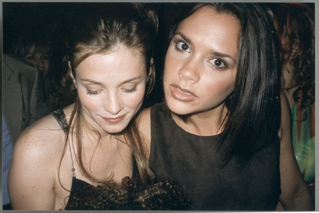 Victoria Beckham attends a party circa 1995, radiating the quiet cool that would soon define her rise to pop culture royalty. Pictured beside actress Anna Friel, she already exudes the poised presence and fashion instincts that hinted at her future global influence.