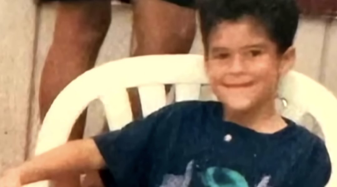 A young Bad Bunny smiles at the camera as he sits in a chair, from a post dated August 31, 2025. | Source: YouTube/TODAY
