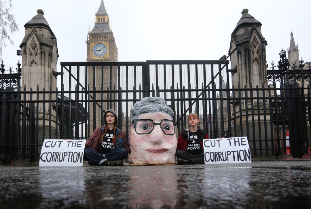 Activists attach themselves to each other in front of the gates of the Houses of Parliament with a lock on, inside a papier-mache head of Keir Starmer on February 6, 2026, in London, England. | Source: Getty Images