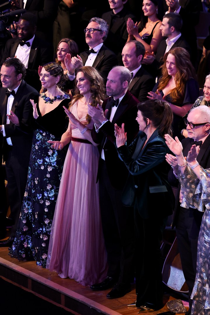 The Prince and Princess of Wales rose to their feet in applause, joining nominees and industry figures in a standing ovation during the 2026 EE BAFTA Awards. Surrounded by a sea of black tie and sequins, the couple clapped in unison, the Princess's maroon waistband and the Prince's velvet jacket subtly linking their formal looks under the stage lights.