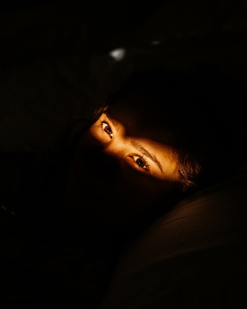 A view of a man's eyes as he lies awake in bed | Source: Unsplash