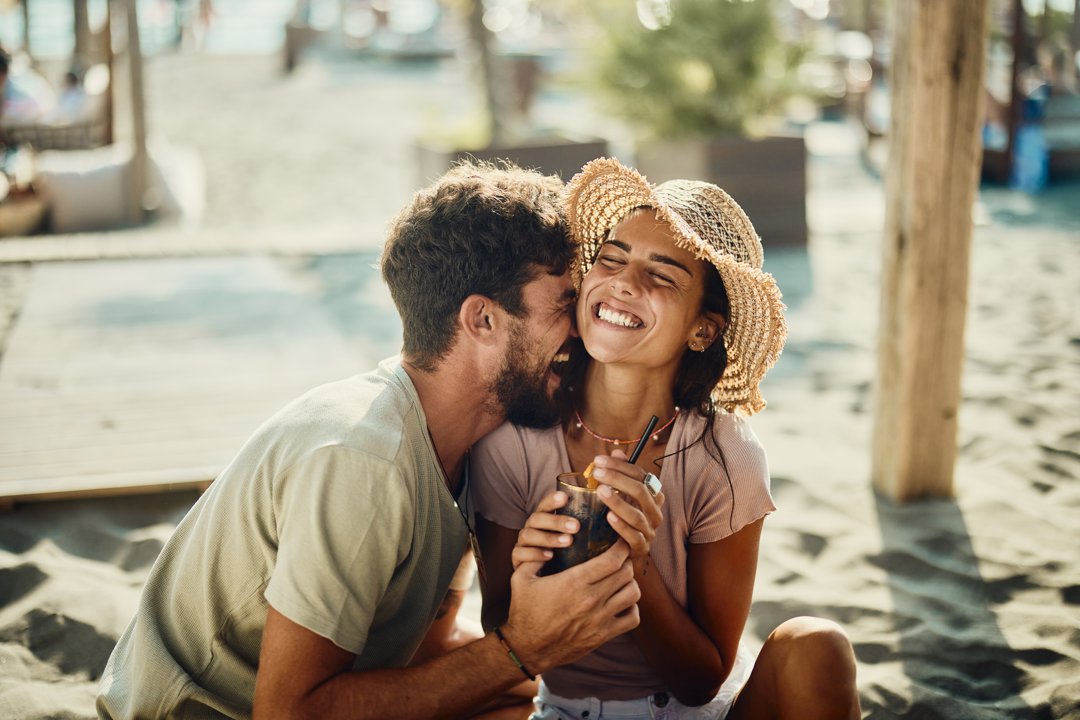 Young happy couple in love having fun in a beach café | Source: Getty Images