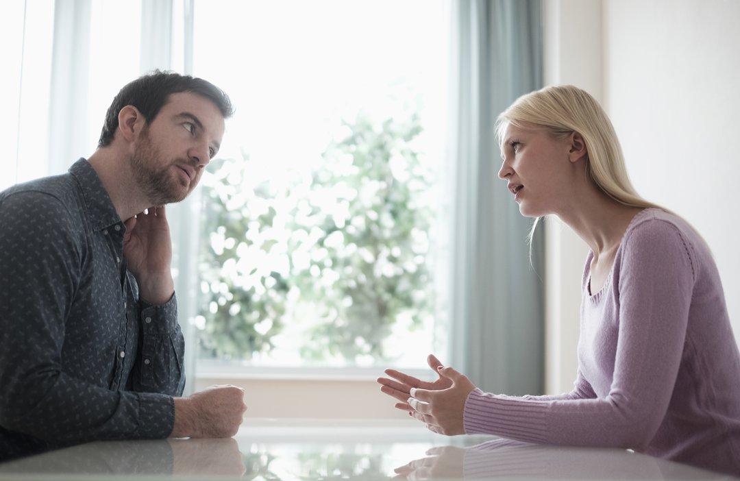 Couple sitting at table, talking | Source: Getty Images