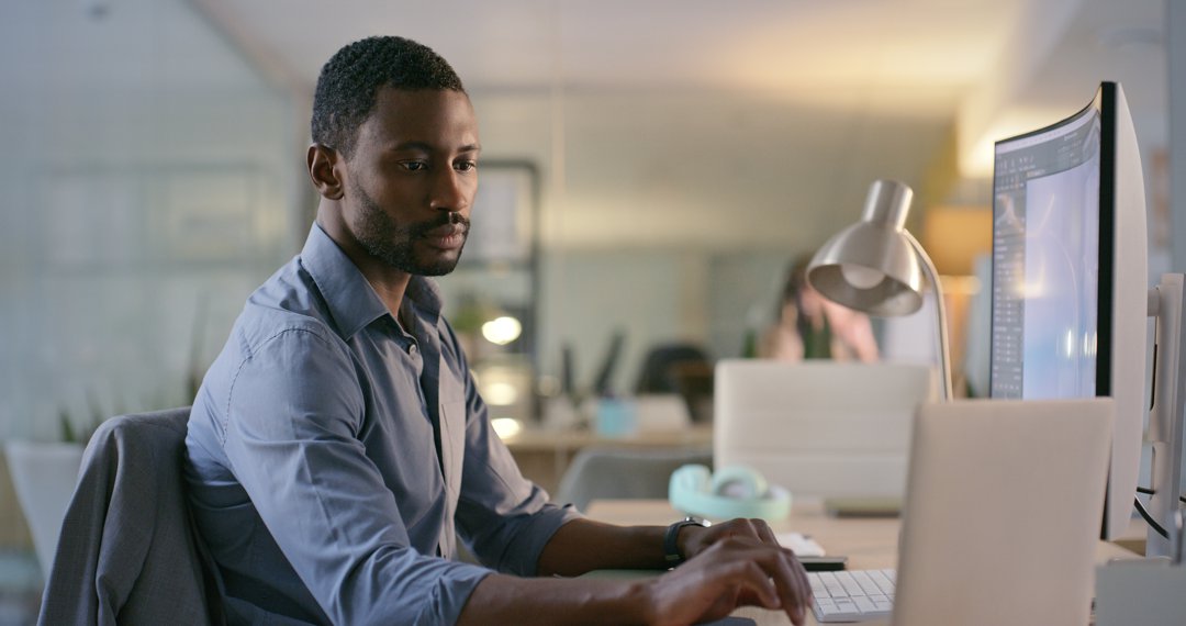 Software designer, engineer or businessman typing on laptop for information technology or cyber security. Computer, search or black man reading web design data for iot digital transformation at night | Source: Getty Images