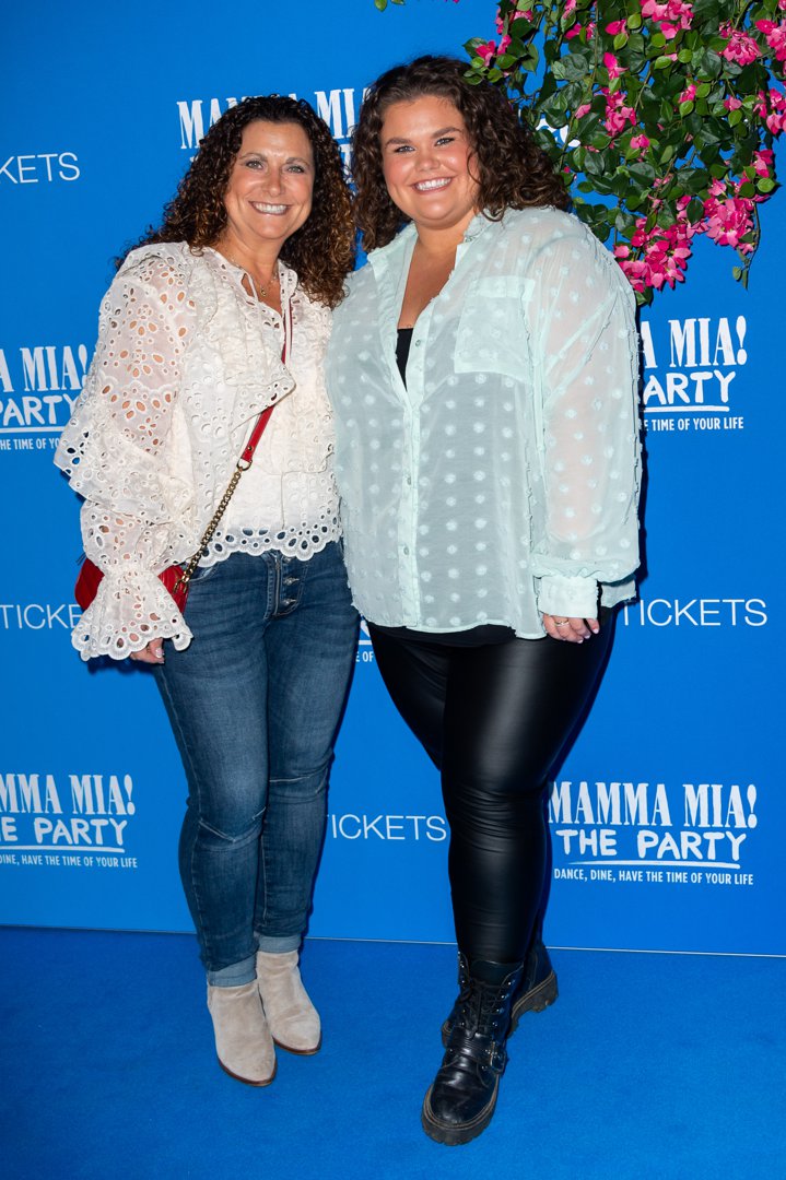 Tapper and her mother Nikki lean in close together on the blue carpet at the