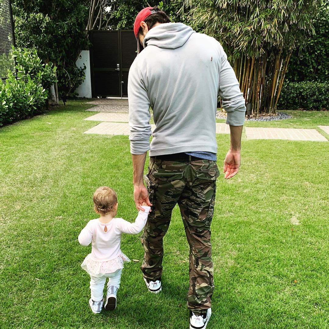 Enrique Iglesias holding Lucy Iglesias's hand while strolling through a backyard, from a post dated March 8, 2019 | Source: Instagram/enriqueiglesias