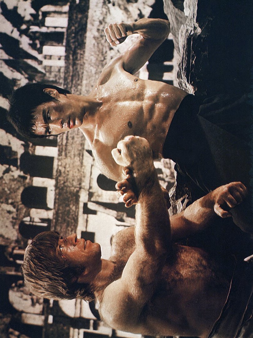 Bruce Lee and Chuck Norris face off in a martial arts stance in 