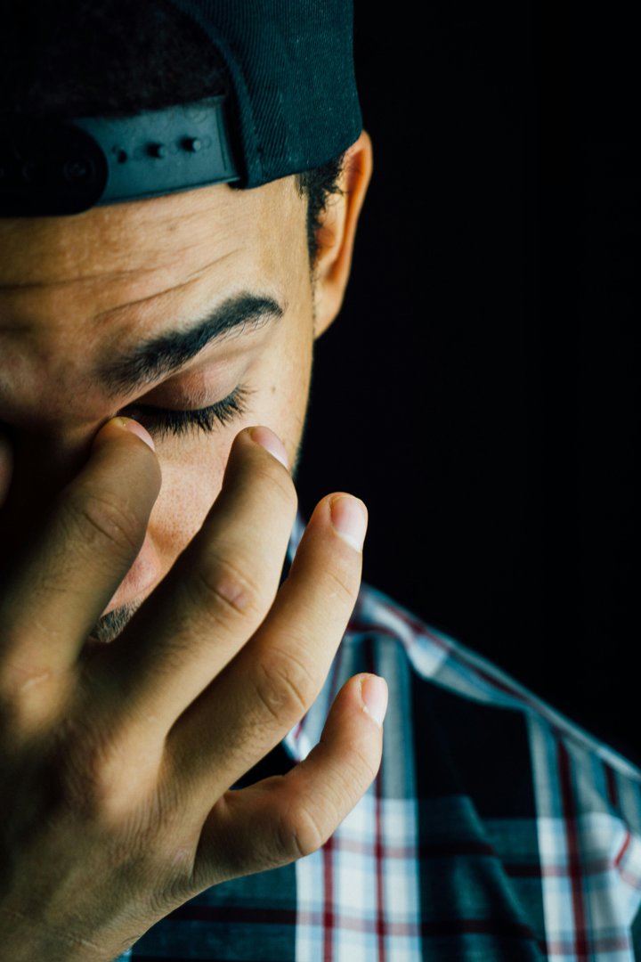 Man pinching his nose in frustration | Source: Pexels