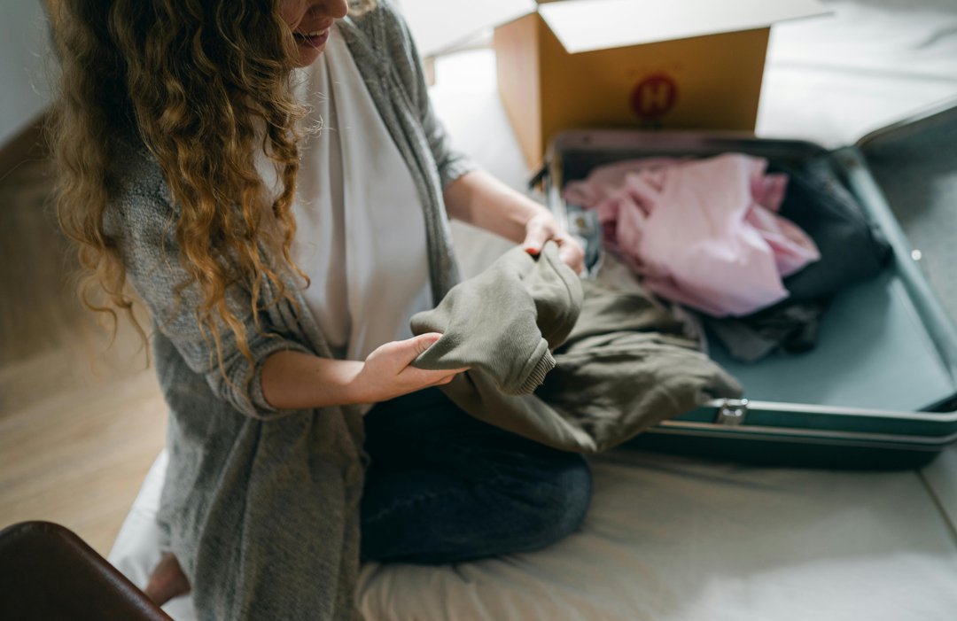 A woman packing her clothes in a bag | Source: Pexels