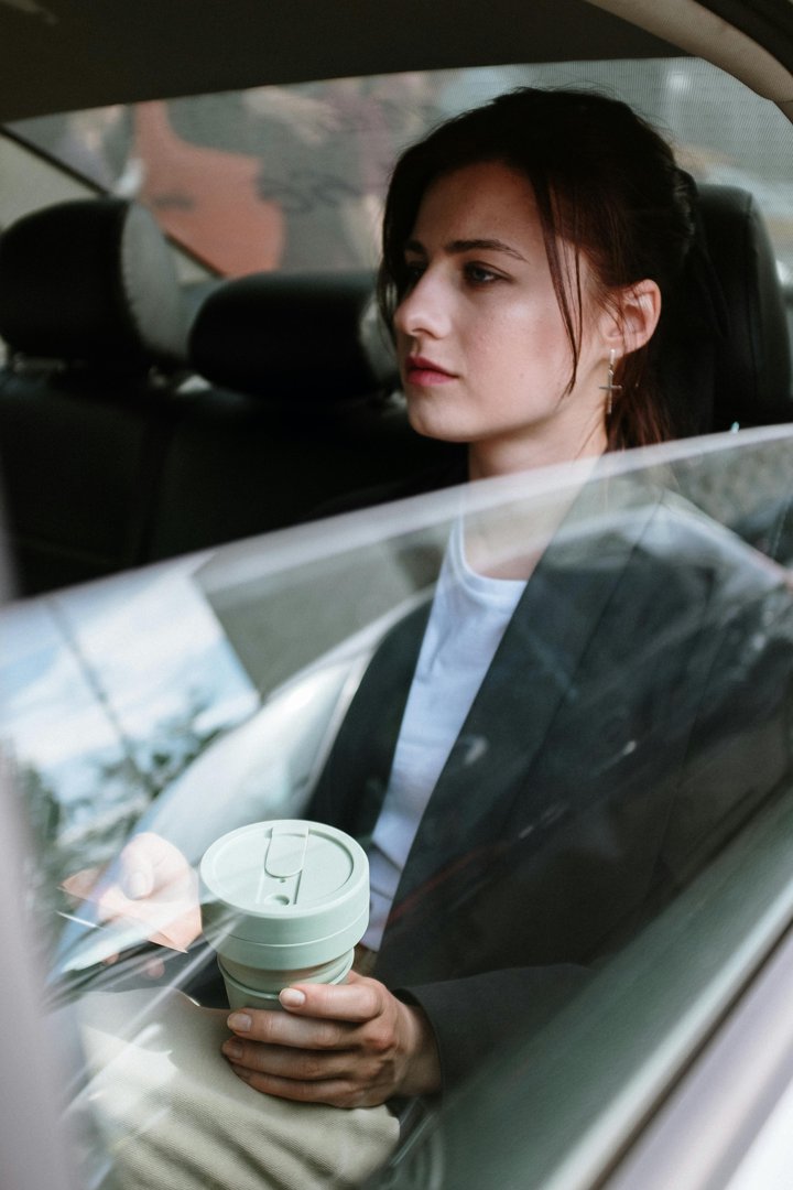 A serious woman in the backseat of a car | Source: Pexels