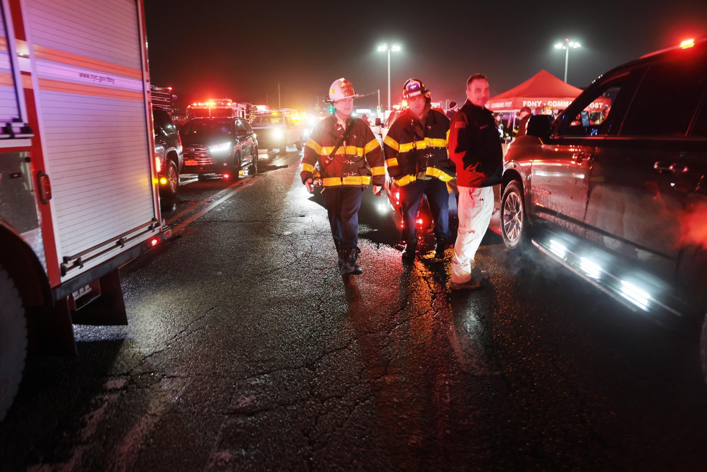 Emergency workers gather at the scene after an Air Canada Express plane collided with a fire truck on the tarmac at LaGuardia Airport on March 23, 2026 | Source: Getty Images
