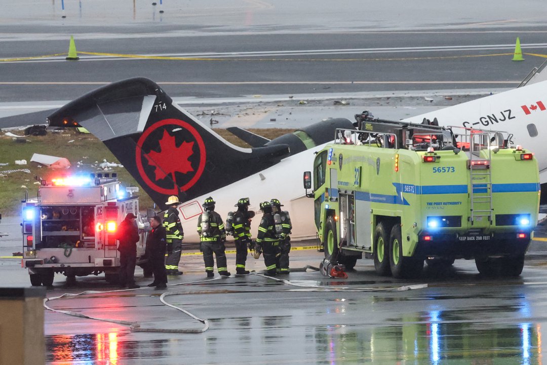 Emergency responders work at the scene where an Air Canada Express CRJ-900 sits on the runway after colliding with a Port Authority fire truck at LaGuardia Airport. | Source: Getty Images