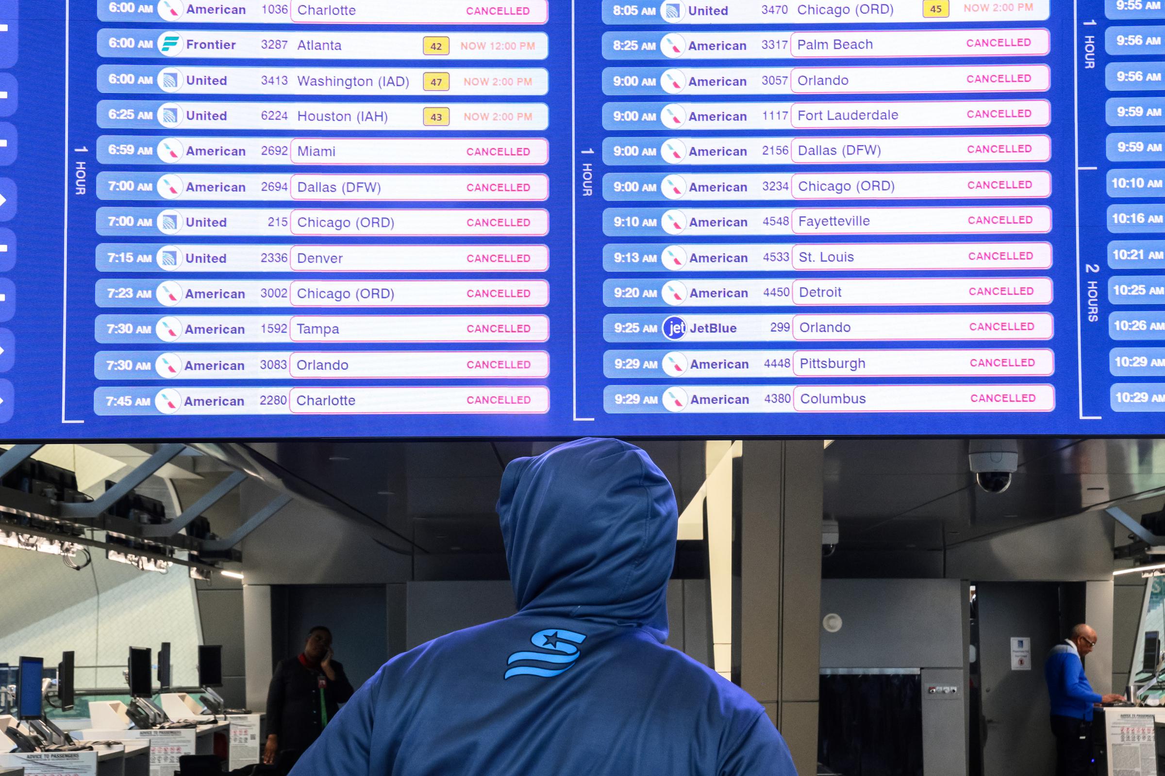A traveler looks at canceled flight schedules on a screen at Terminal B in LaGuardia Airport in New York City on March 23, 2026. | Source: Getty Images