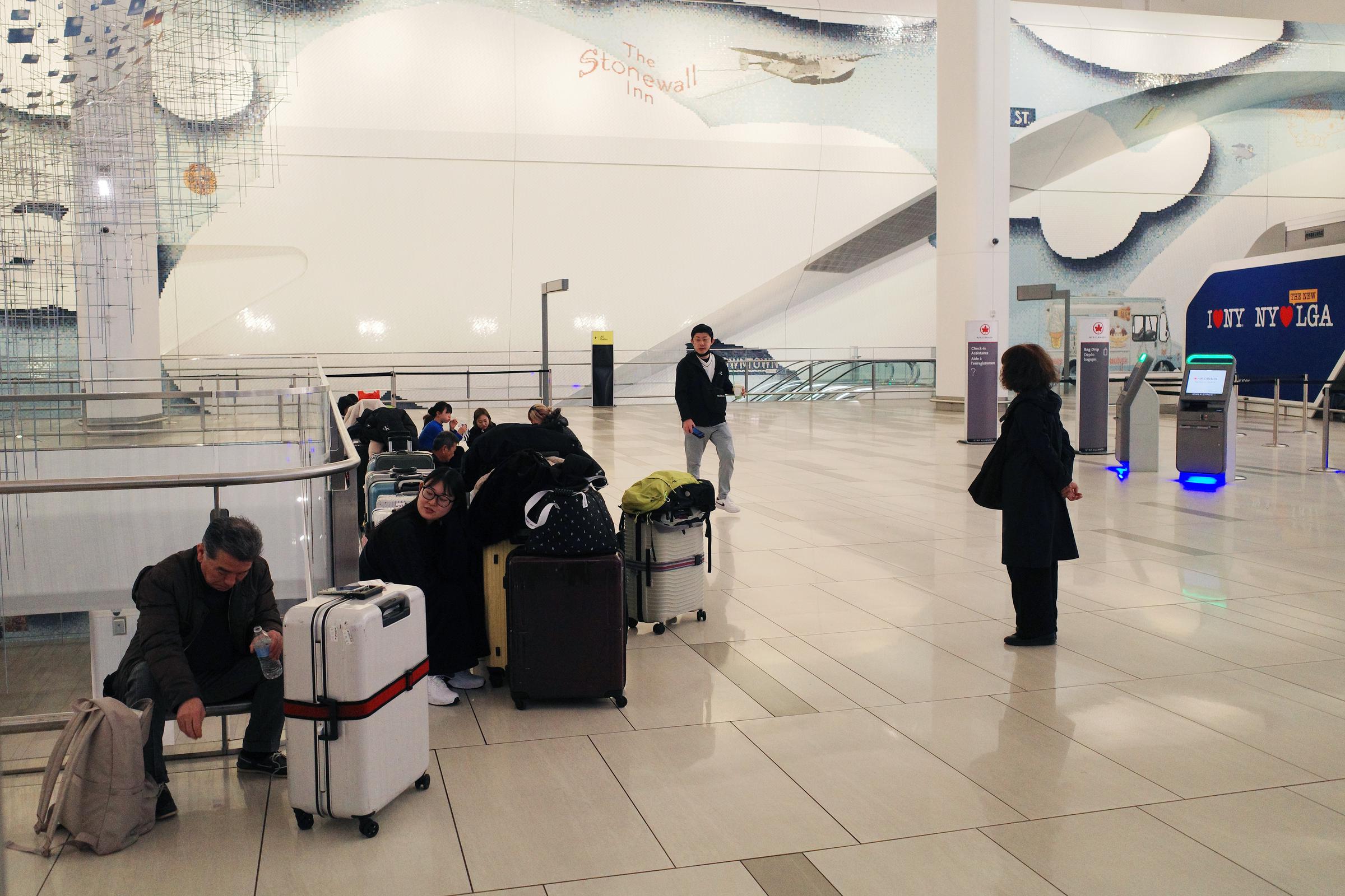 Travelers wait inside LaGuardia Airport after flight cancellations in New York City on March 23, 2026 | Source: Getty Images