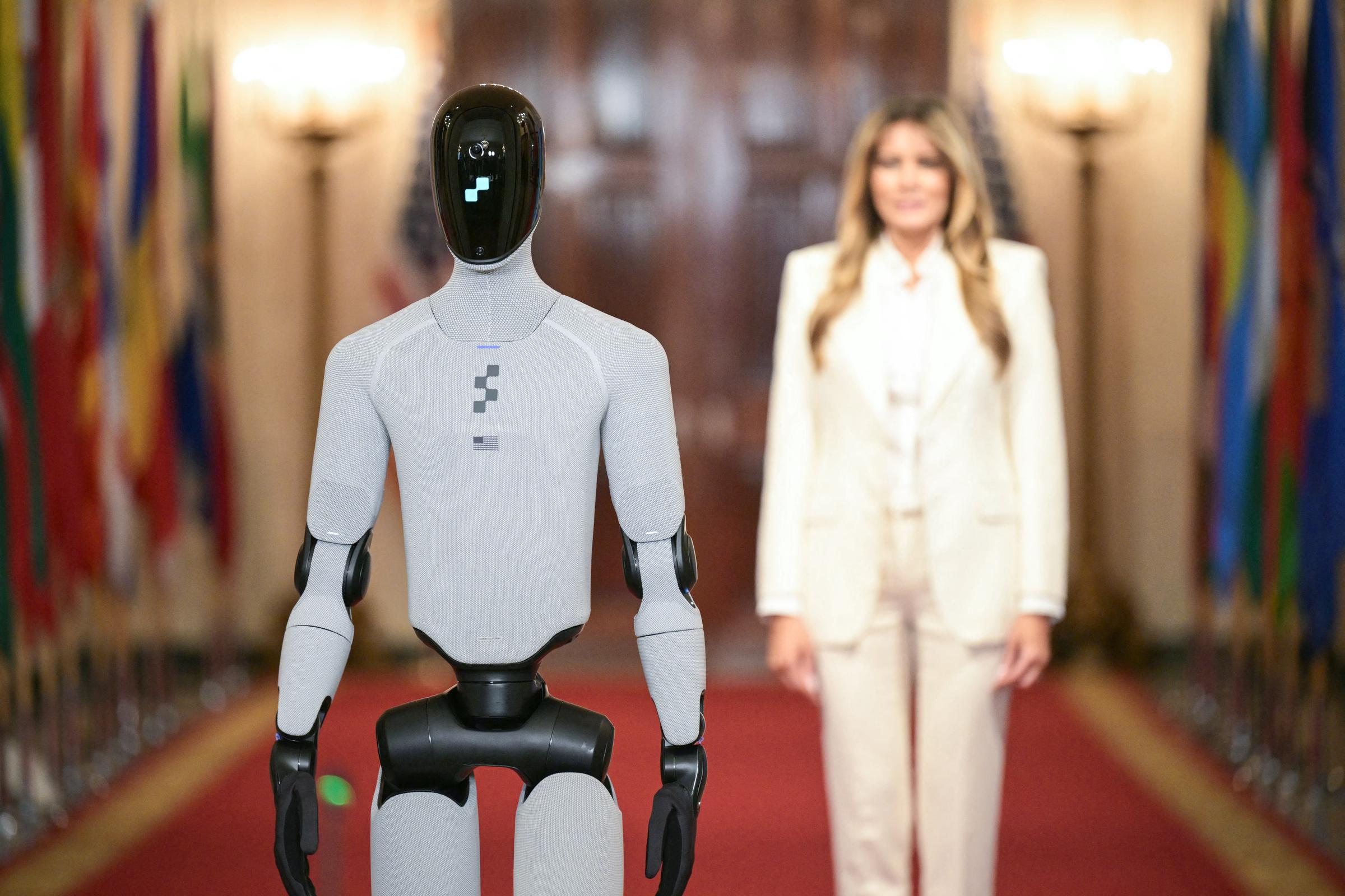 The humanoid robot walks ahead of Melania Trump at the Global Coalition Summit at the White House on March 25, 2026. | Source: Getty Images