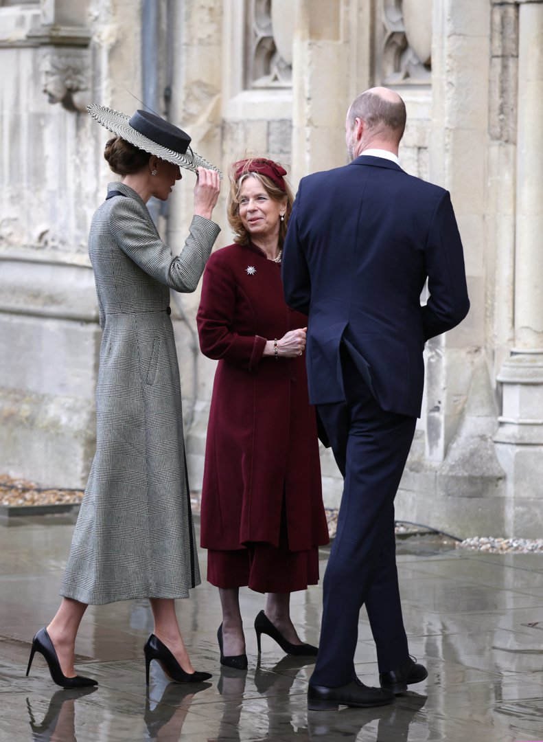 One hand up, hat firmly gripped &mdash; the Princess of Wales gets her first real taste of the Canterbury wind as she pauses to chat outside the cathedral's ancient stone walls. Prince William, in a navy suit, stands beside her with his back to the camera, seemingly unaffected, while the wide houndstooth brim tilts at a precarious angle that told the whole story before the internet even got to it.