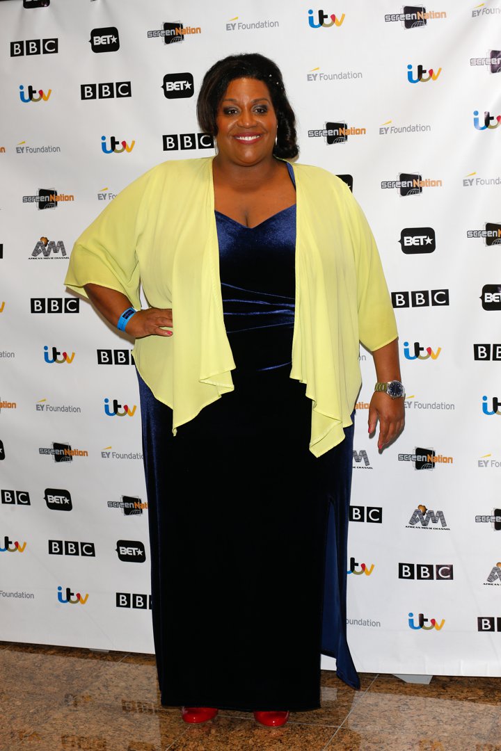 Wearing a navy velvet gown with a flowing yellow wrap, Hammond turns heads at the Screen Nation Film & Television Awards on 19 March 2016. She adds a burst of colour with red heels as she smiles for photos against a backdrop of BBC, ITV and Screen Nation logos.