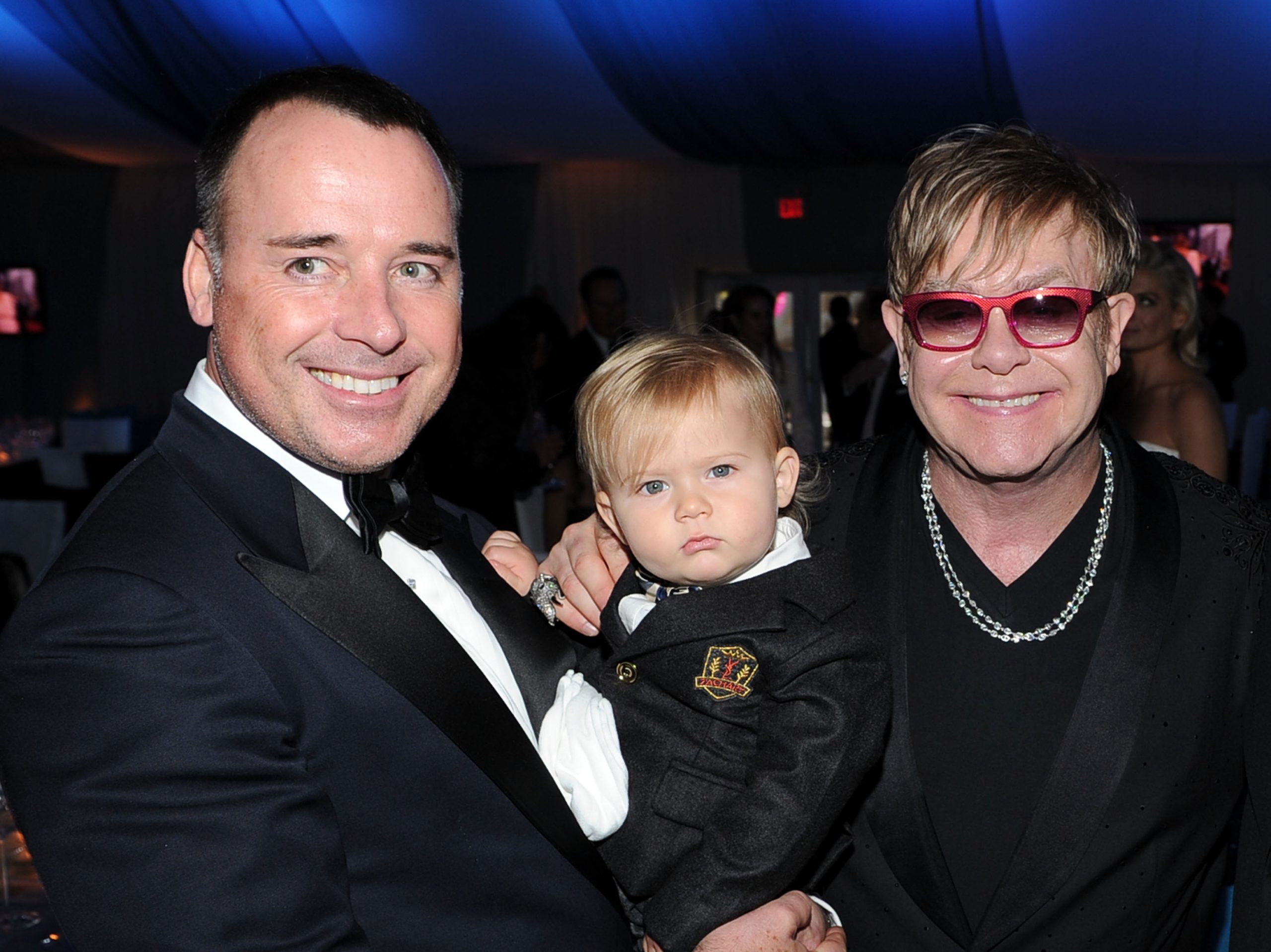 David Furnish and Sir Elton John arrived in polished black tie for the 20th Annual Elton John AIDS Foundation Academy Awards Viewing Party on February 26, 2012, in California, United States &mdash; but it was toddler Zachary John Furnish-John who quietly stole the spotlight. Dressed in a miniature suit with a crisp white shirt and tiny tie, the youngster was held between his fathers as they smiled for photographers.