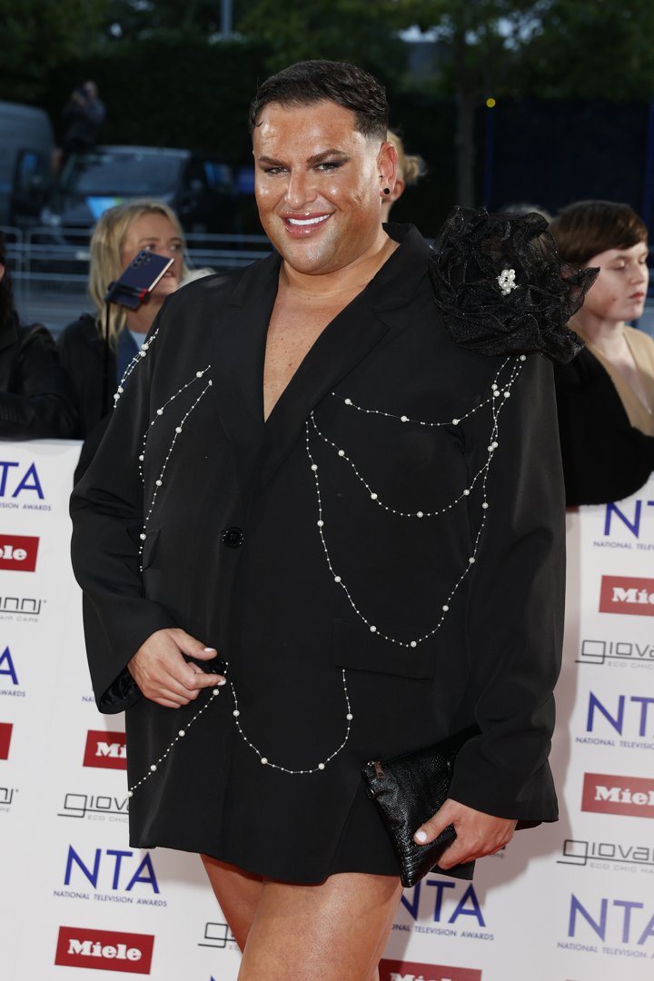Potts stuns in statement couture at the 2025 National Television Awards, arriving at The O2 Arena on 10 September in a black blazer dress adorned with pearl chain draping and a dramatic floral shoulder detail. With a sleek black clutch in hand and a glossy, confident smile, the reality star owns the spotlight once again.