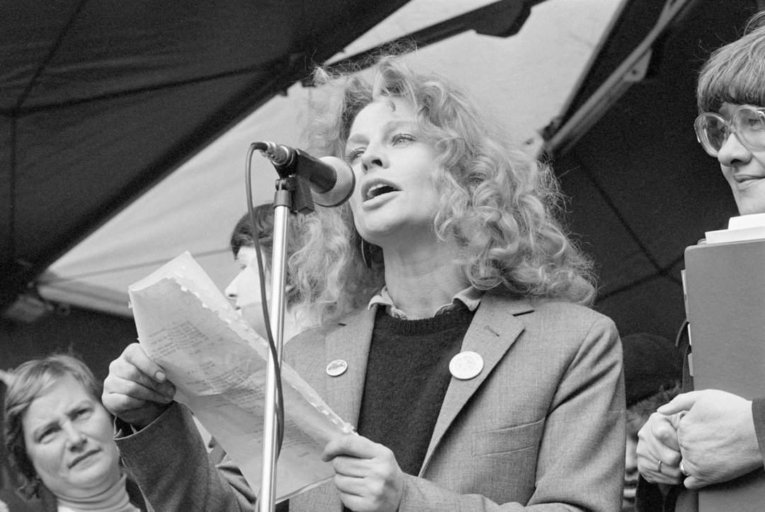 Christie addresses a crowd in Brussels' Place Rogier Square as thousands of women from more than twenty countries gather to protest nuclear weapons and call for peace. Holding her notes at the microphone, Christie lends her voice to the powerful international demonstration &mdash; a moment that reflects her long-standing commitment to activism beyond the screen.