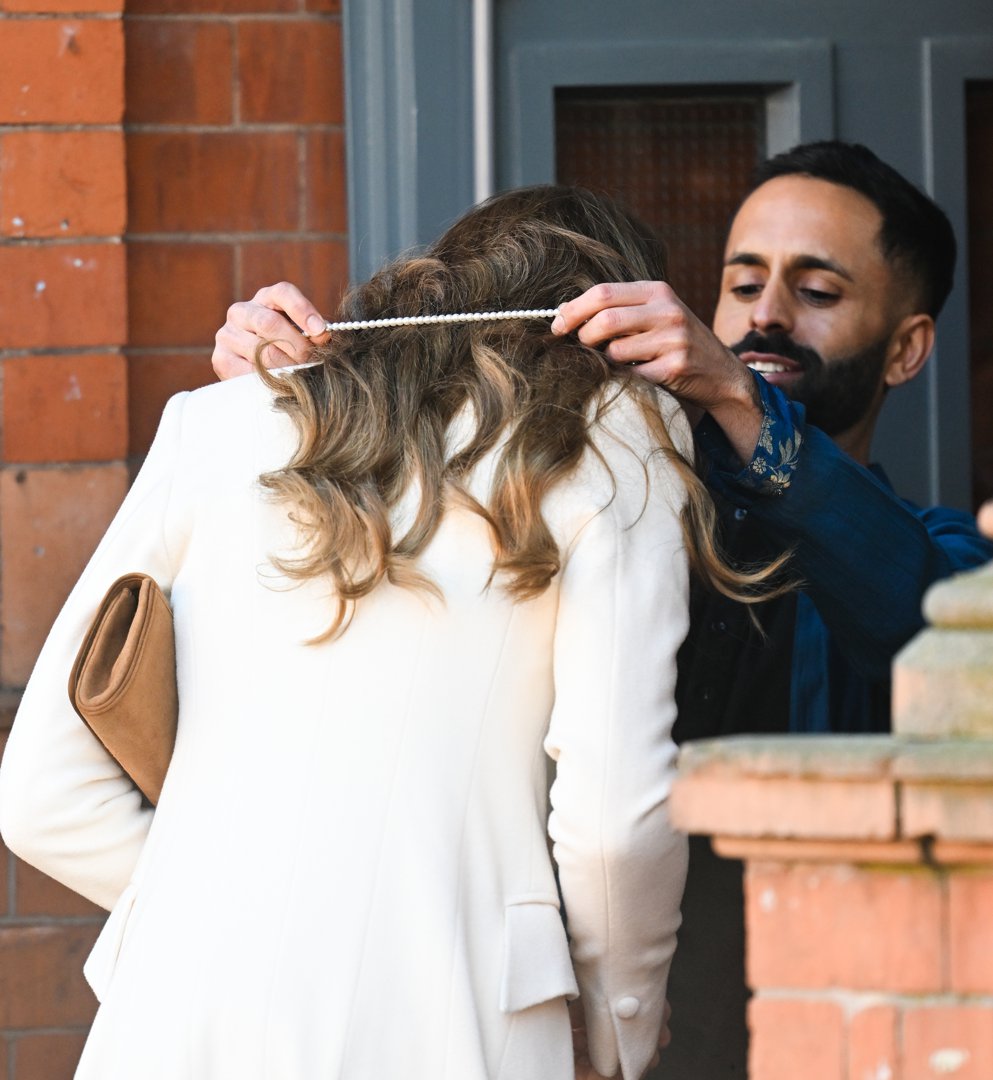 Catherine, Princess of Wales, bows her head slightly as a host places a delicate garland around her neck upon arrival at the Aakash Odedra Company in Leicester on March 5, 2026. The welcoming gesture, offered as she stepped inside the building, formed part of the traditional greeting extended to the Princess of Wales at the start of her visit celebrating dance, culture, and the local community.
